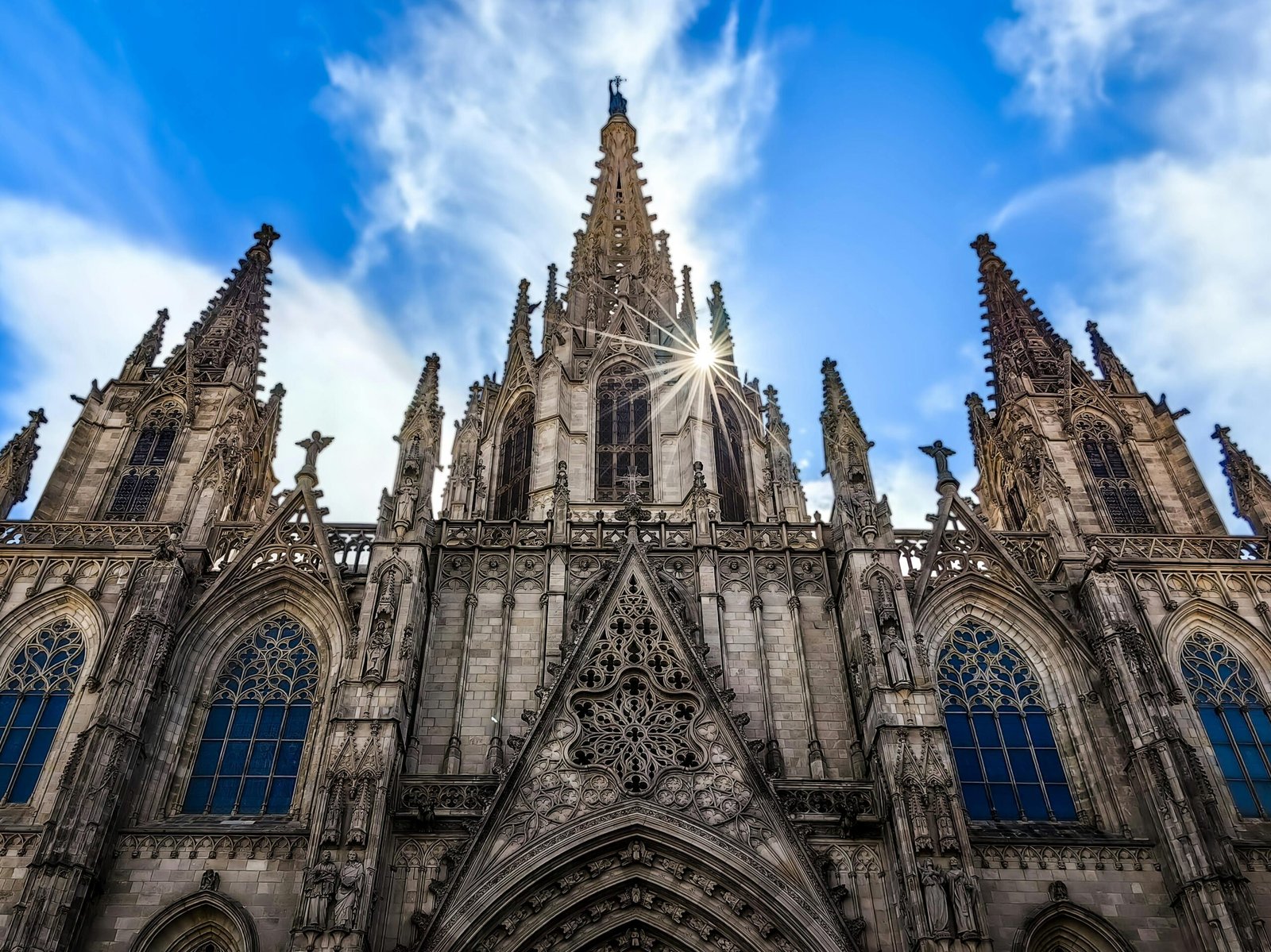 Stunning Gothic architecture of the Barcelona Cathedral with a sunburst on the facade.