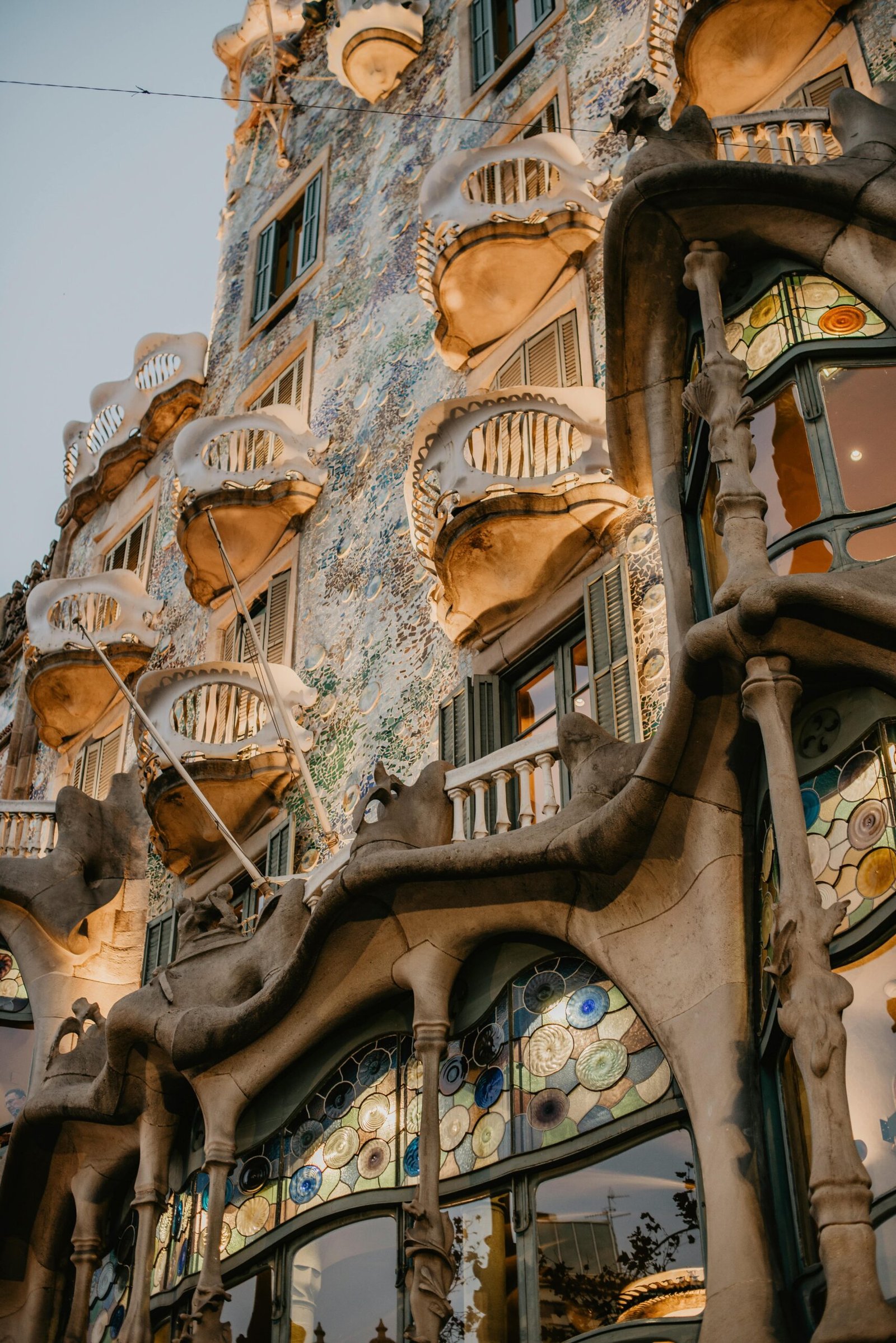 A detailed view of Casa Batlló's unique Gaudí design facade in Barcelona at dusk.