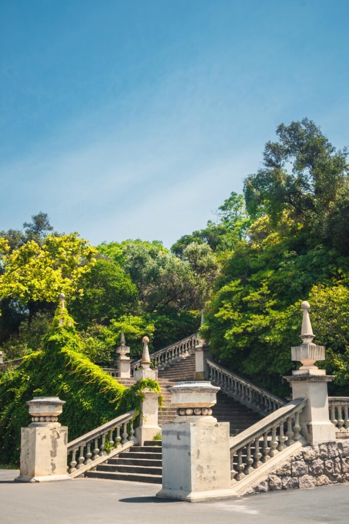 Elegant stone staircase surrounded by lush greenery in a Barcelona park.
